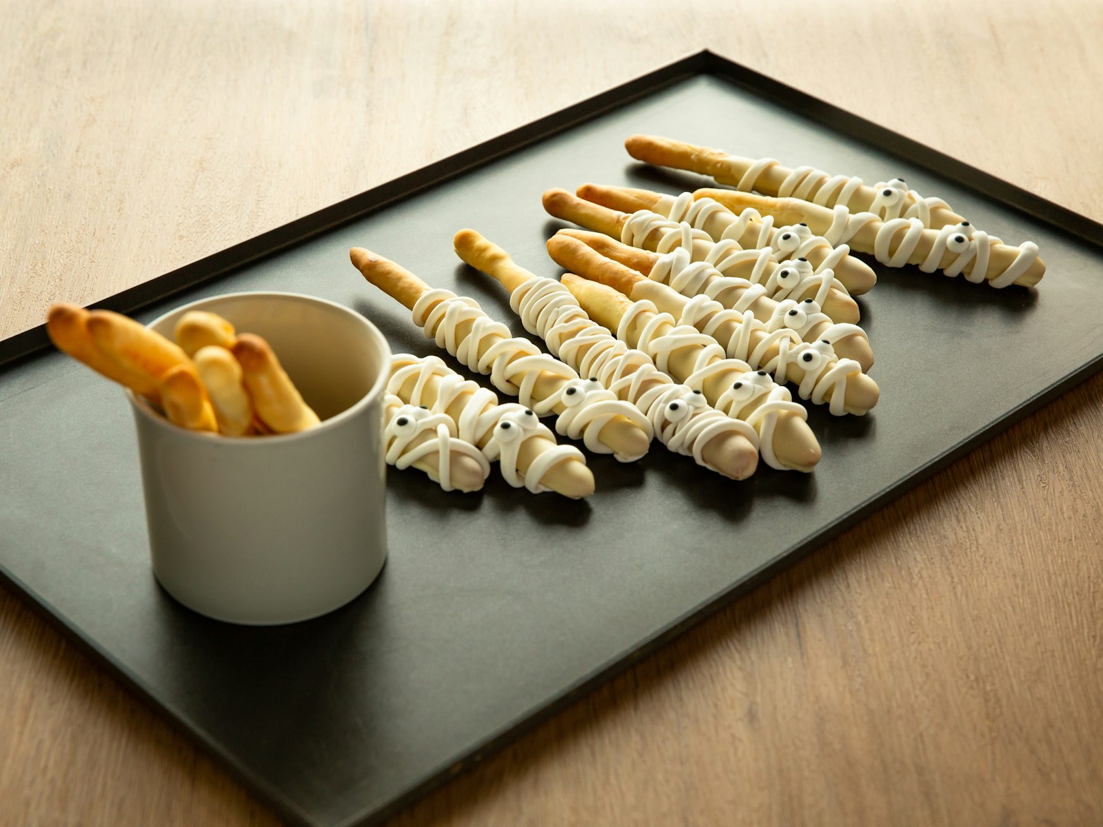 Cheese straws on a baking tray with a dip