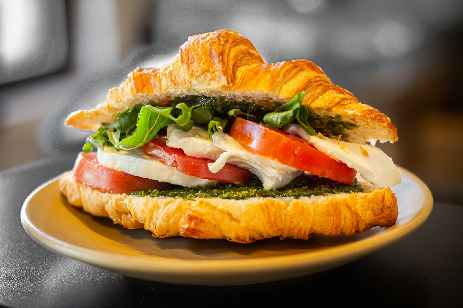 Flaky croissant filled with tomato, mozzarella and greens