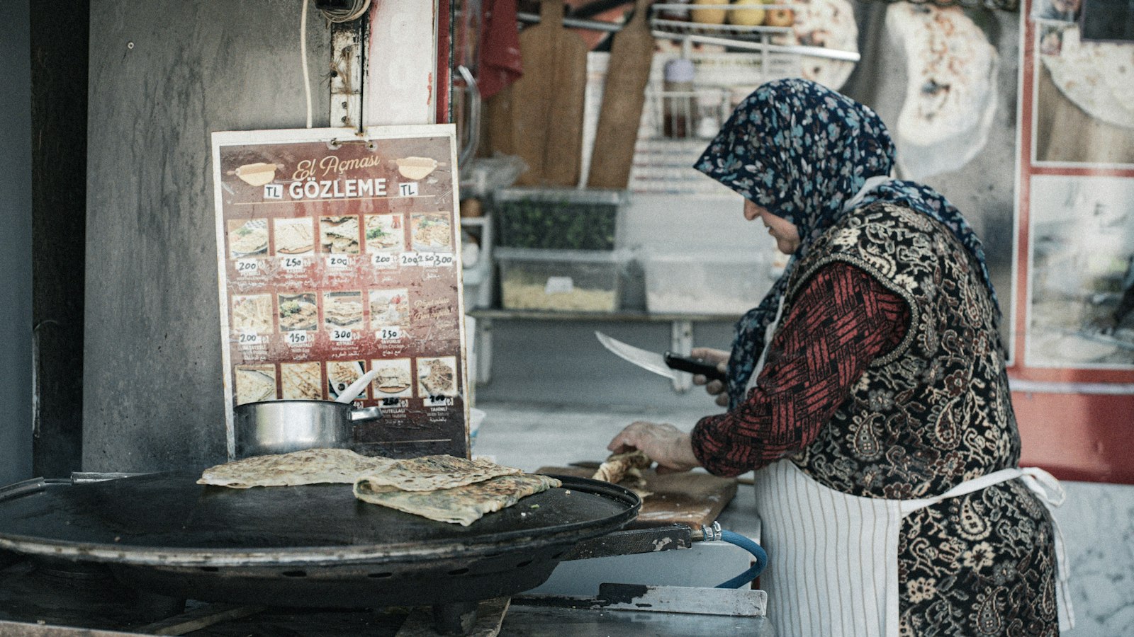 Woman cooking gozleme on a market griddle