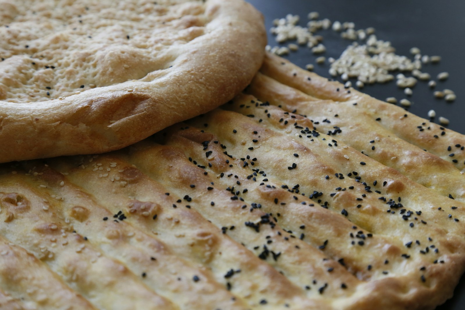 Naan topped with nigella seeds on a board