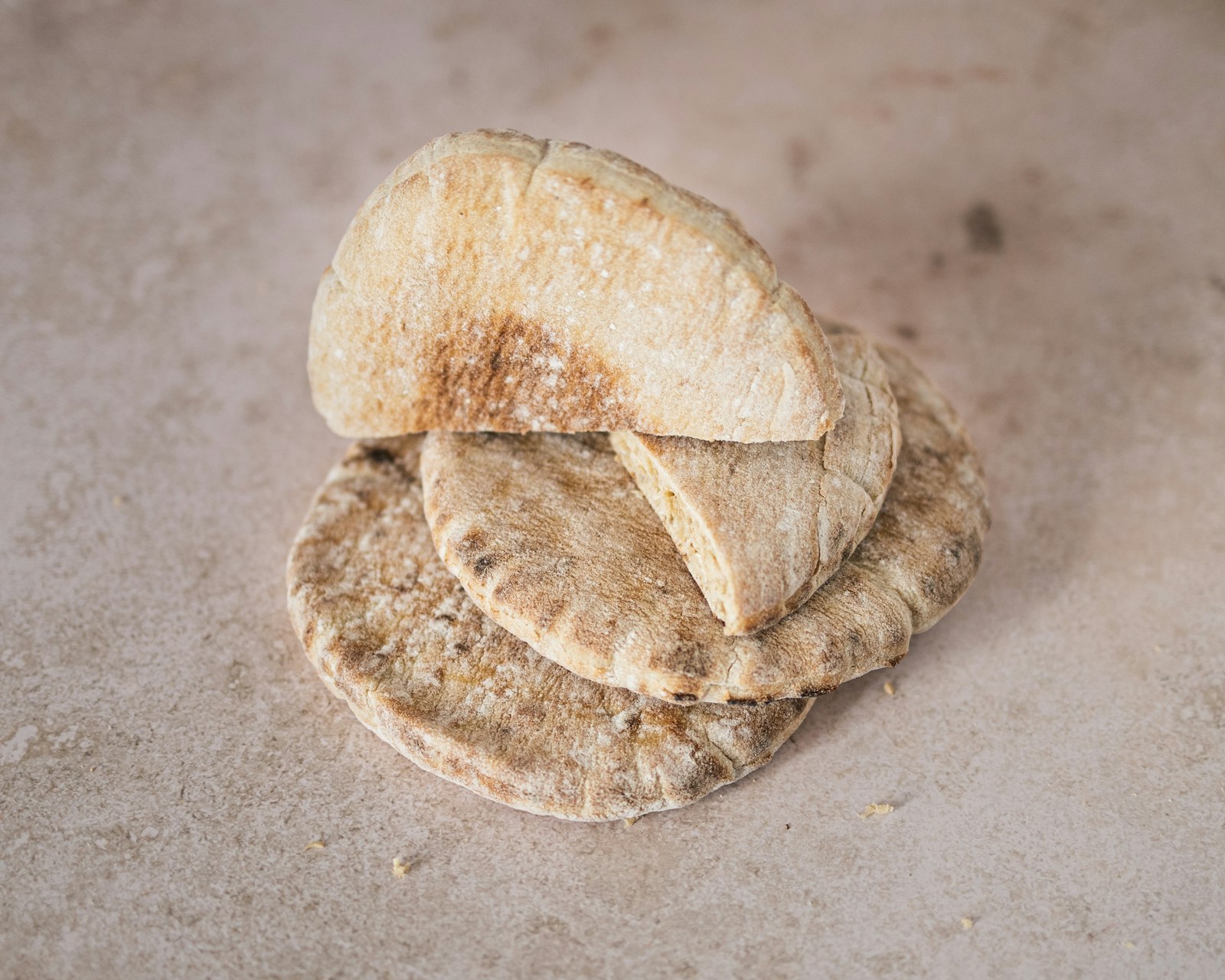 Puffy homemade pita flatbread stacked on a table