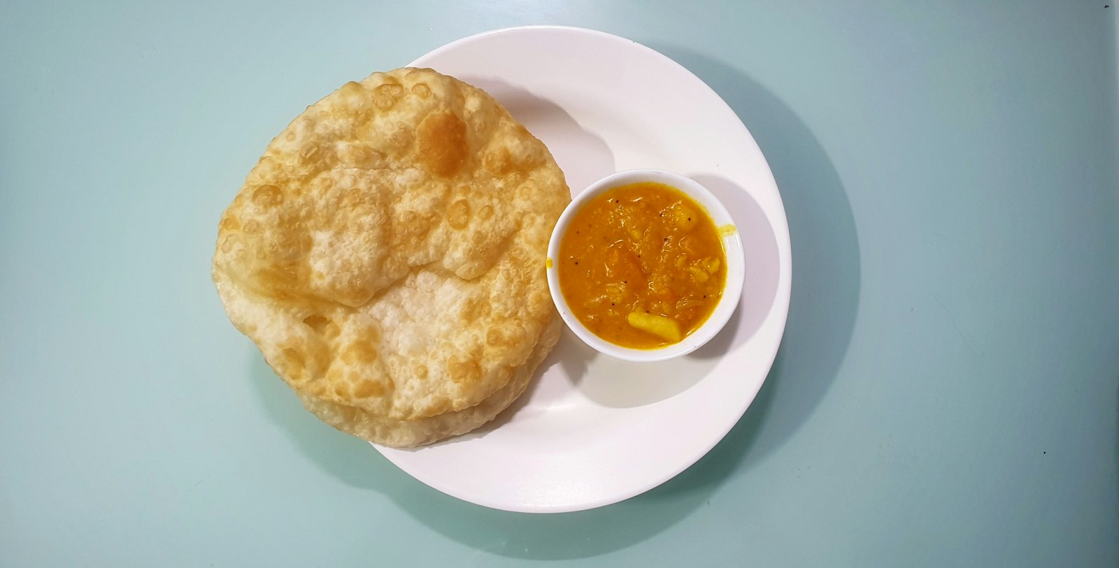 Puffed puri bread with potato curry