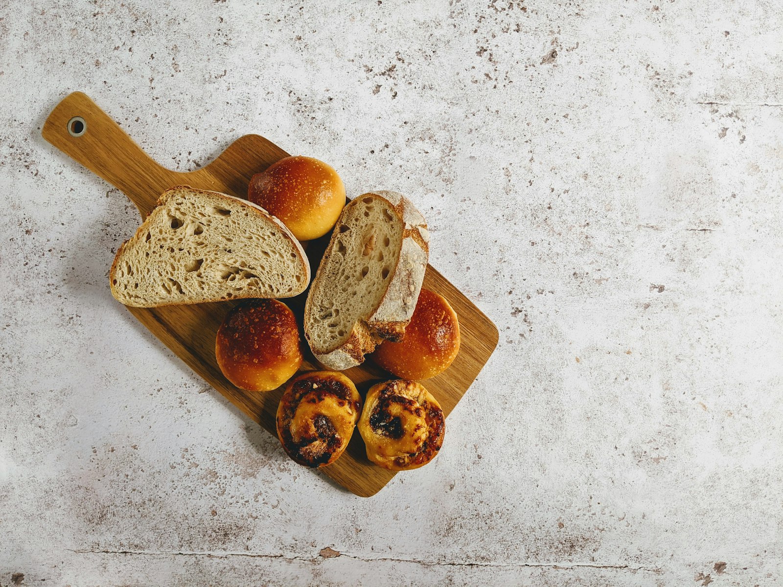 Small crusty rolls on a wooden serving board