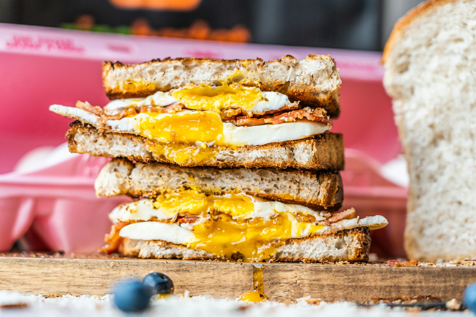 Stack of toasted egg and cheese squares with runny yolk