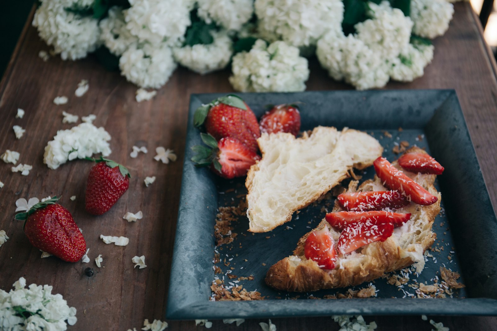 Strawberry wedge with fresh berries on a dark tray