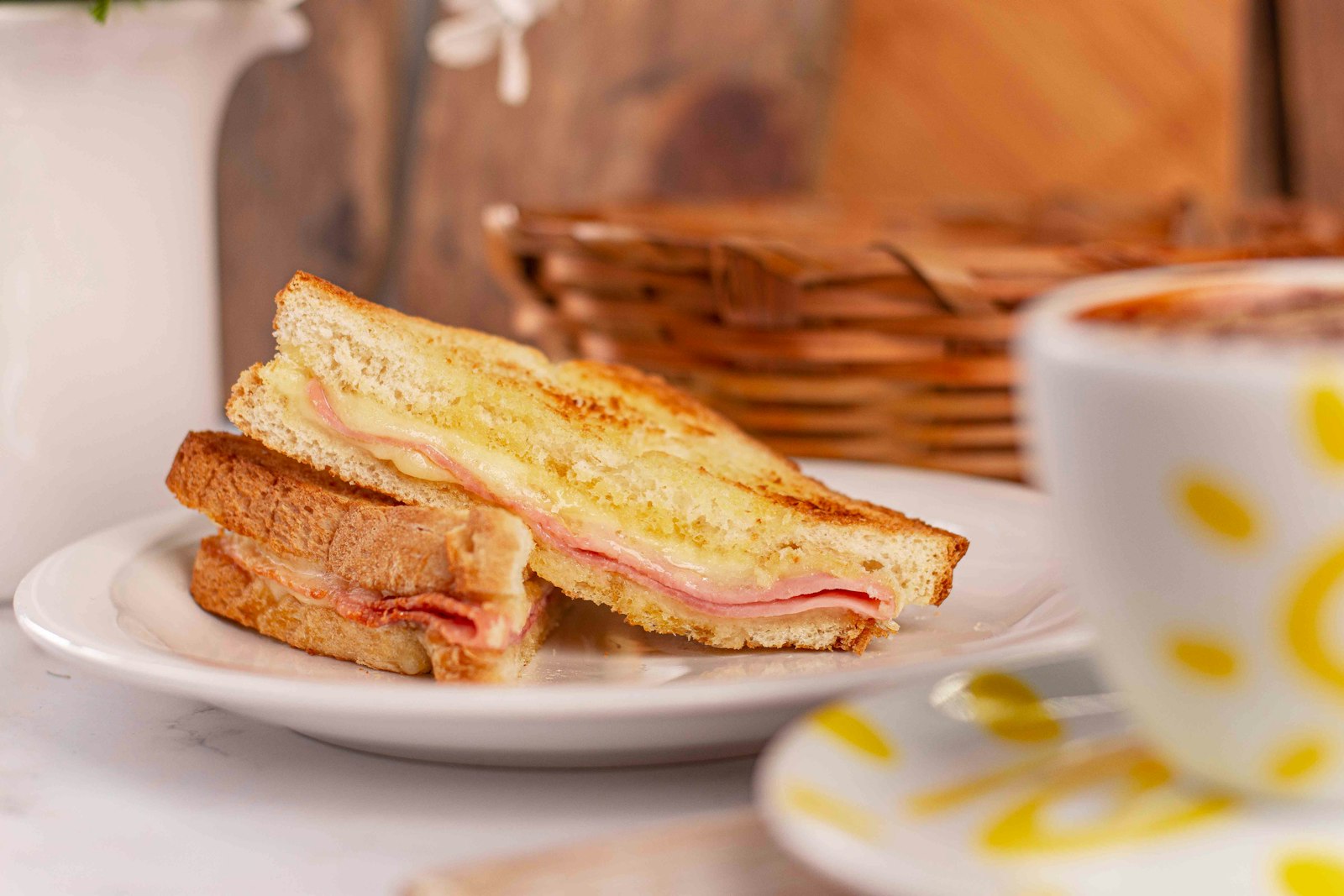 Ham and cheese toastie cut in half on a plate