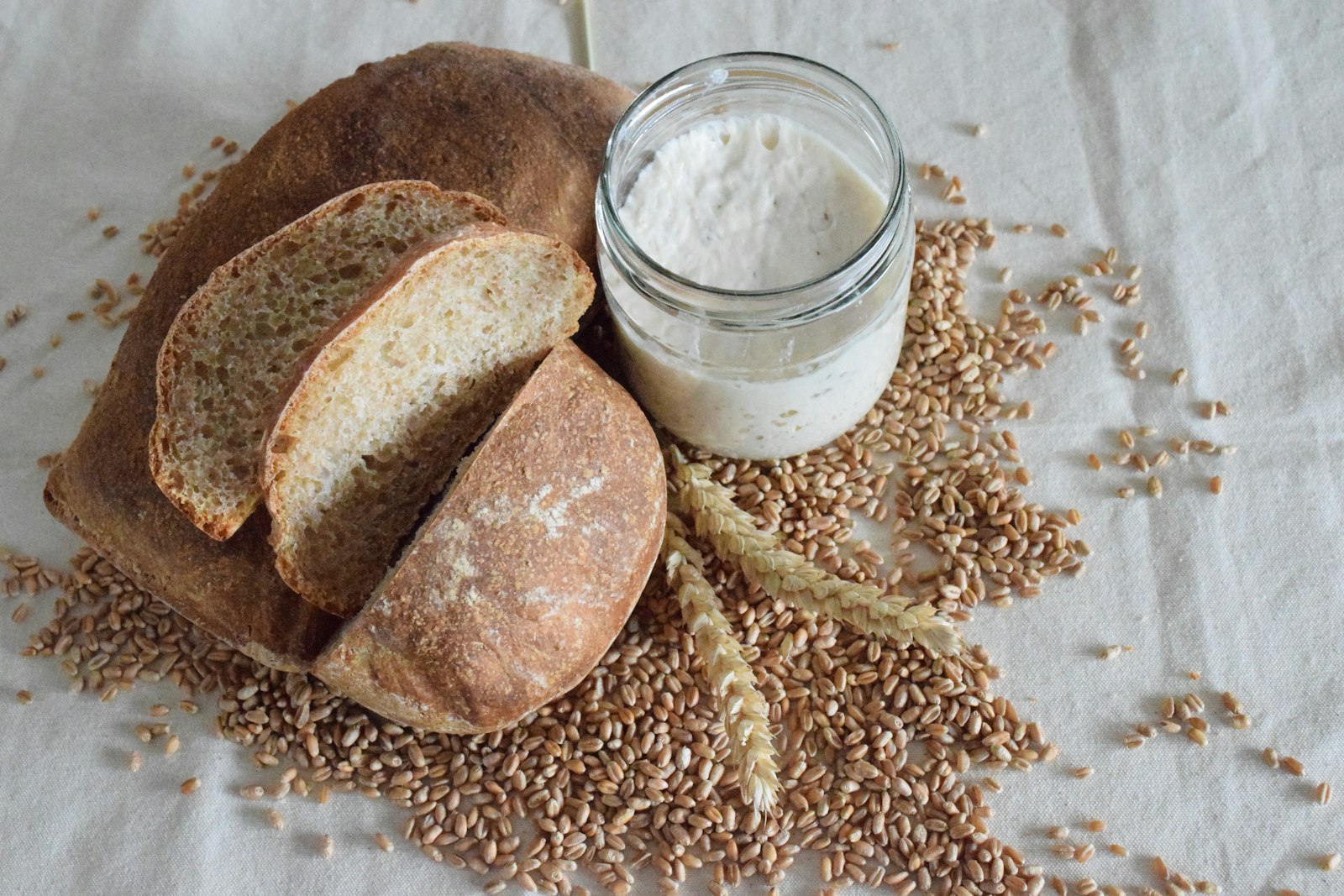 Whole wheat loaf from easy sourdough recipes with a jar of flour