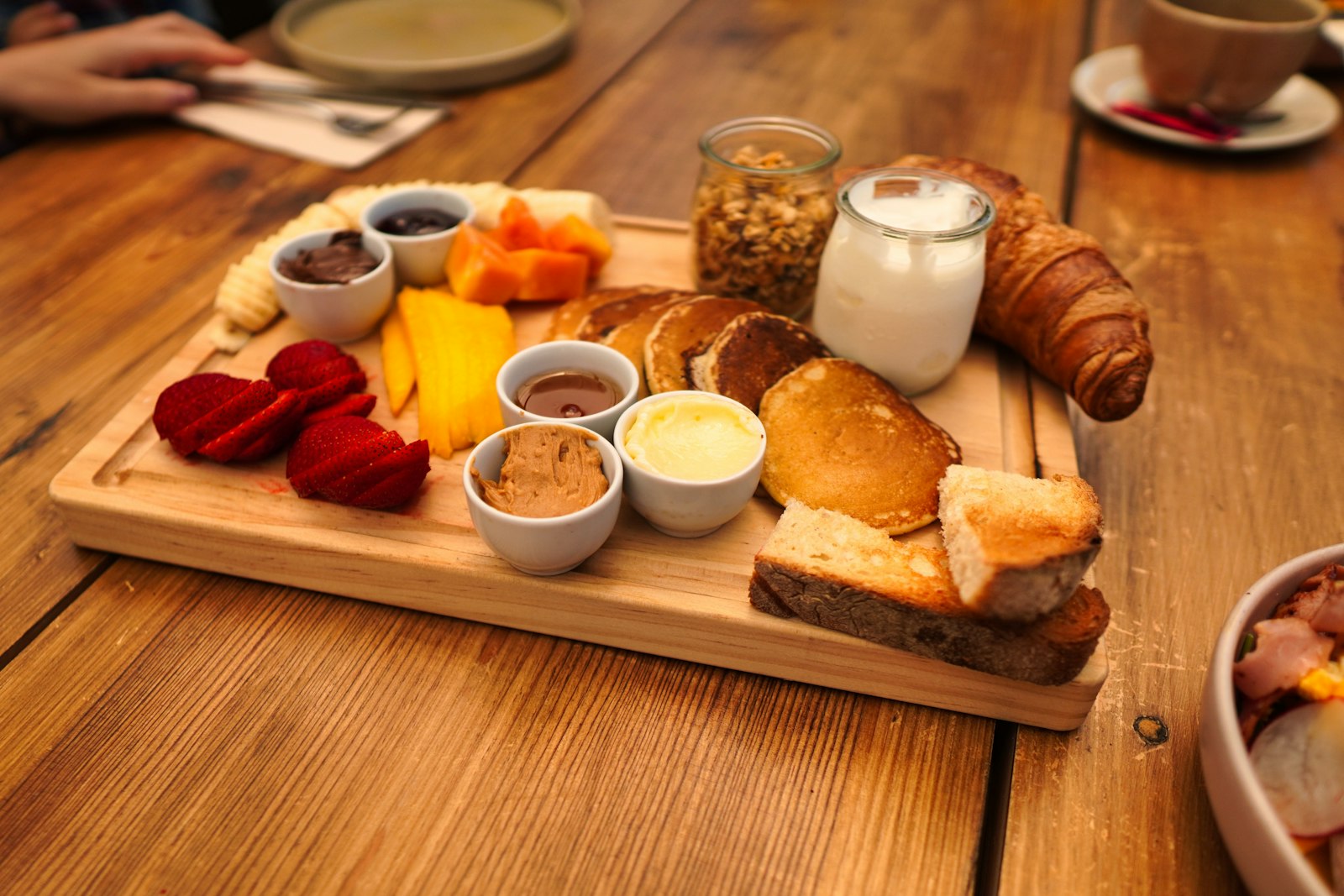 Brunch board with croissants, butter and jam
