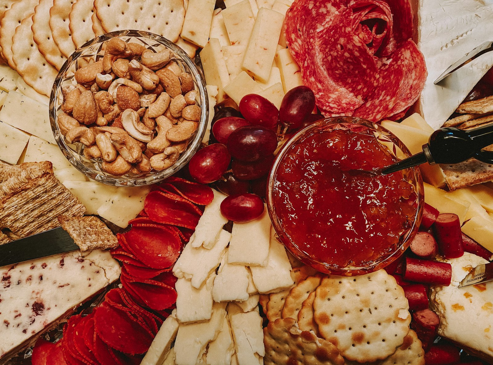 Christmas cheese board ideas with nuts, jam and red decorations