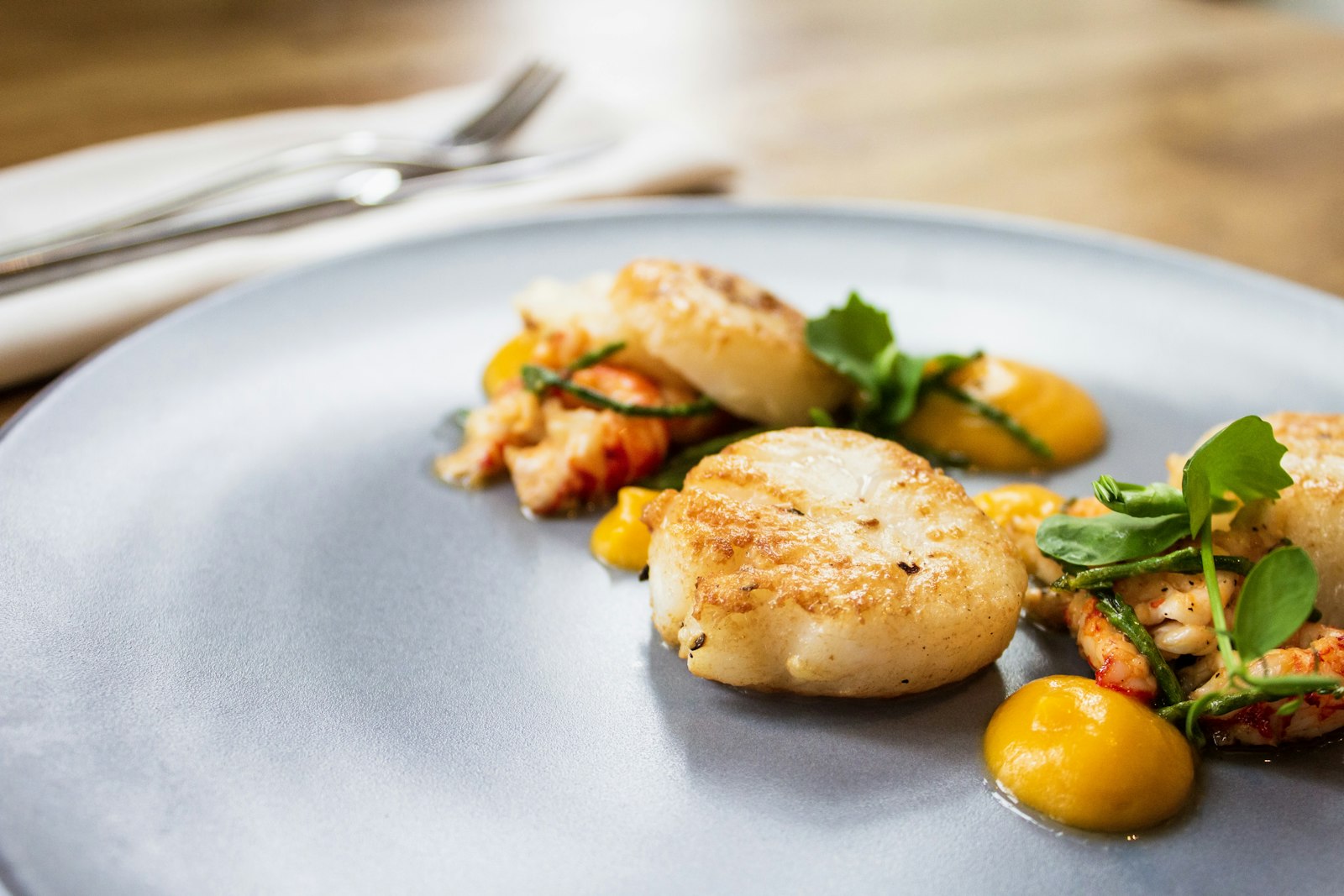 golden seared scallops on a white plate