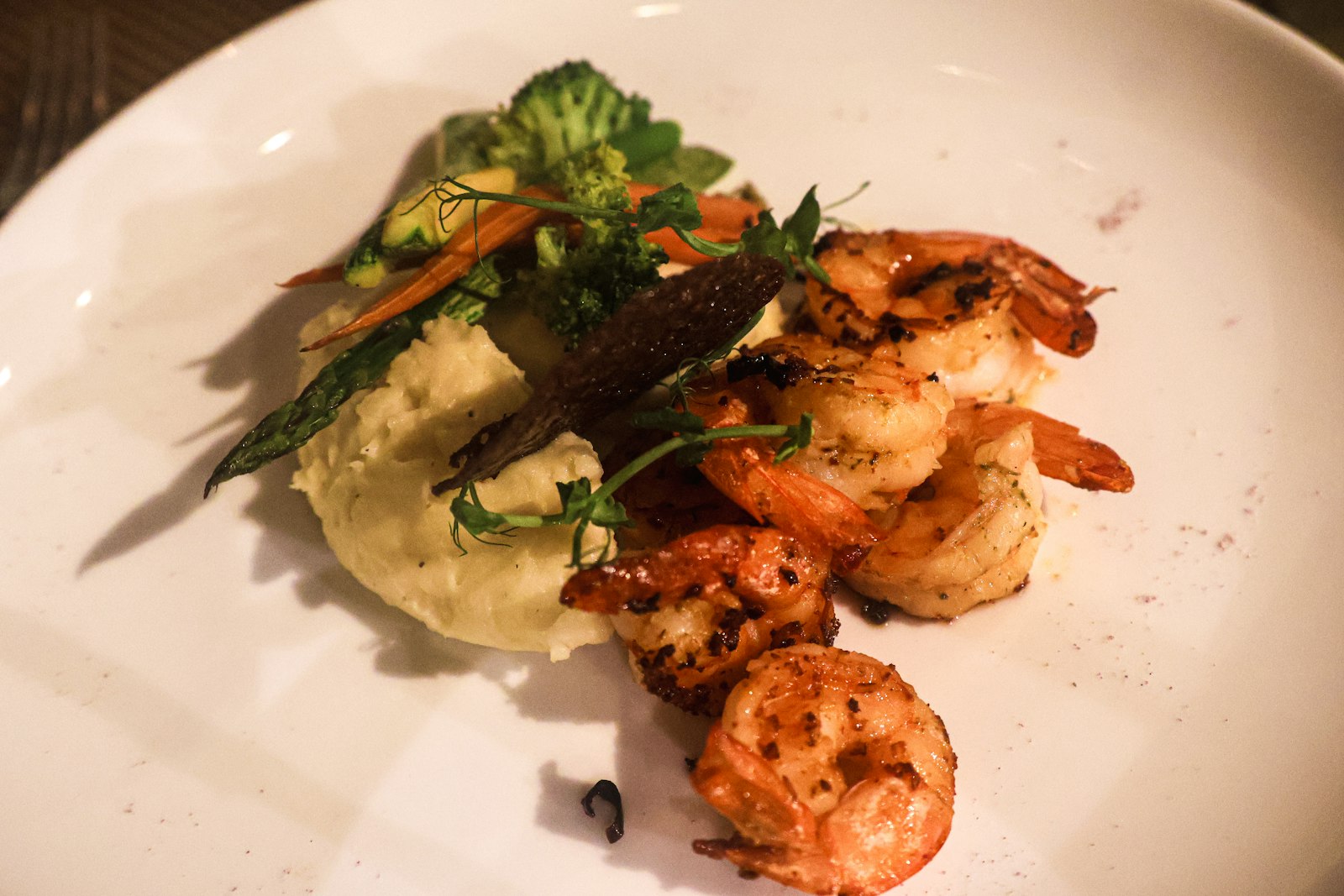 grilled shrimp with creamy grits and sides on a white plate