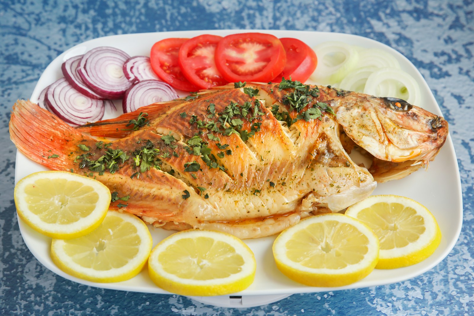 Whole grilled fish with lemon slices