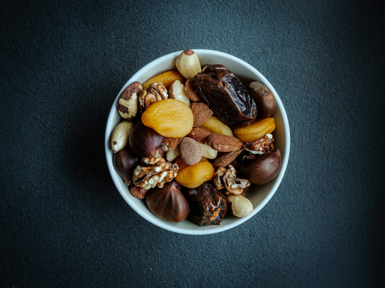 Bowl of homemade trail mix with nuts and dried fruit, one of the best pre workout snacks
