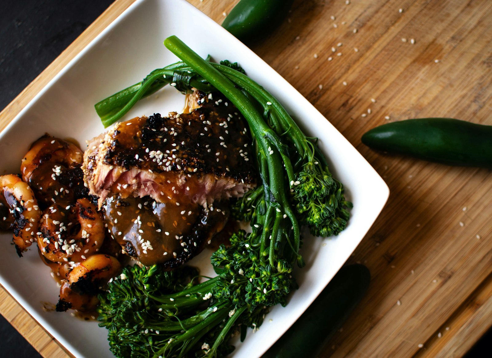 Sticky honey garlic chicken with broccolini on a white plate