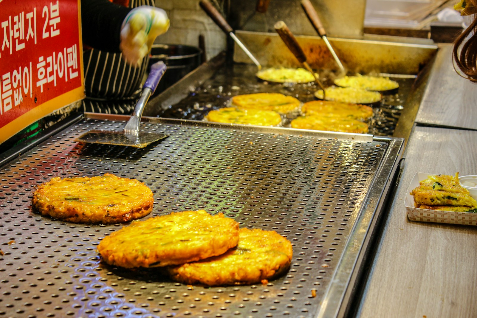 Korean hotteok sweet pancakes on a griddle