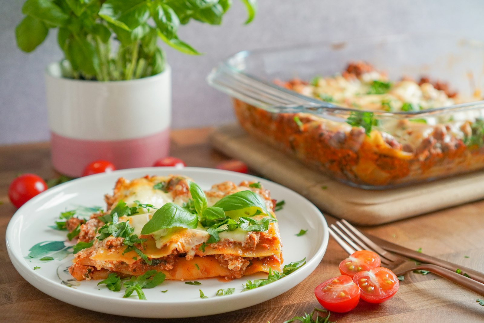 Slow cooker dinners: slice of cheesy lasagna on a plate with the baking dish behind it