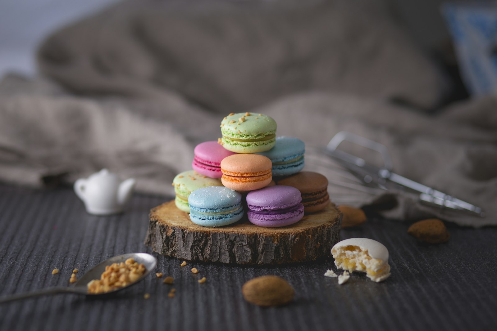 Colorful macarons stacked on a wood slab