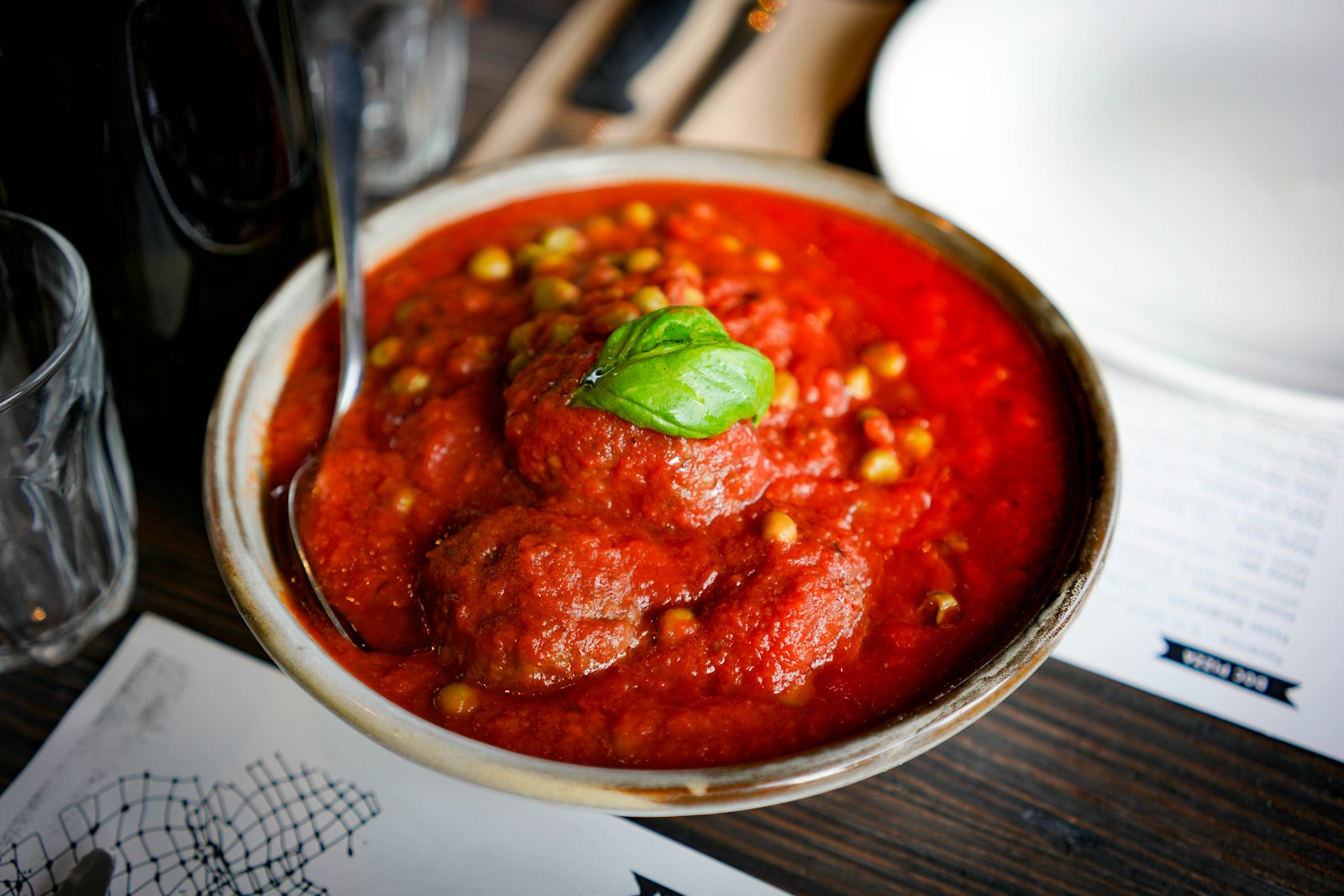 Meatballs in rich tomato sauce topped with fresh basil