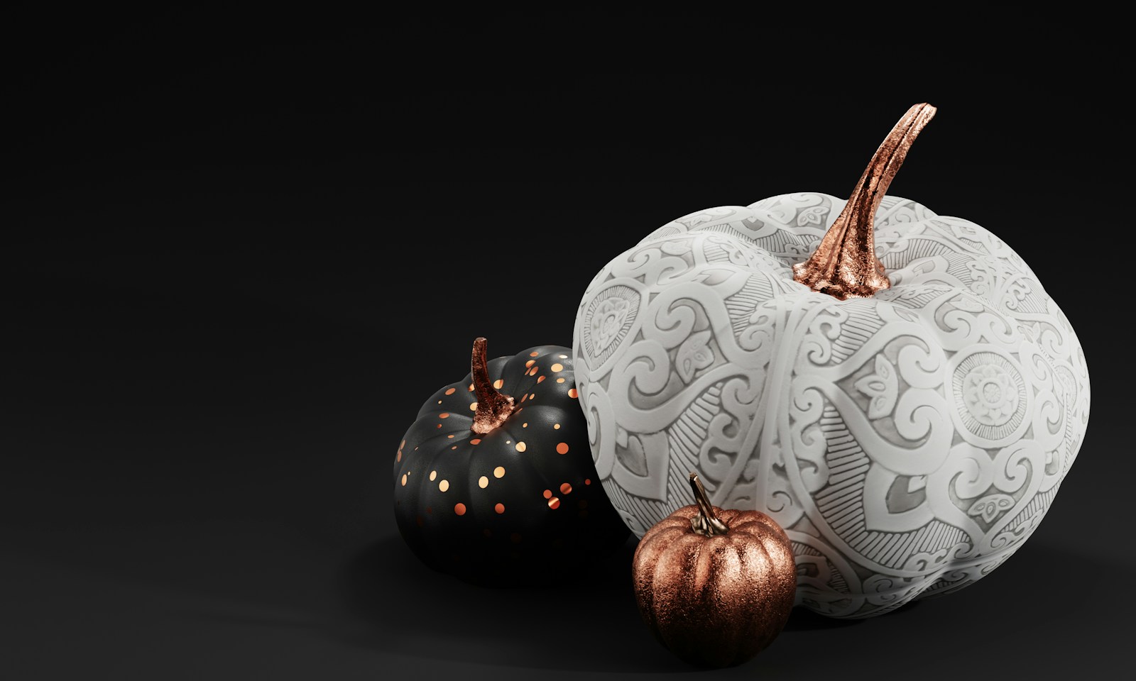 White pumpkin with a painted lace pattern next to a small black dotted pumpkin
