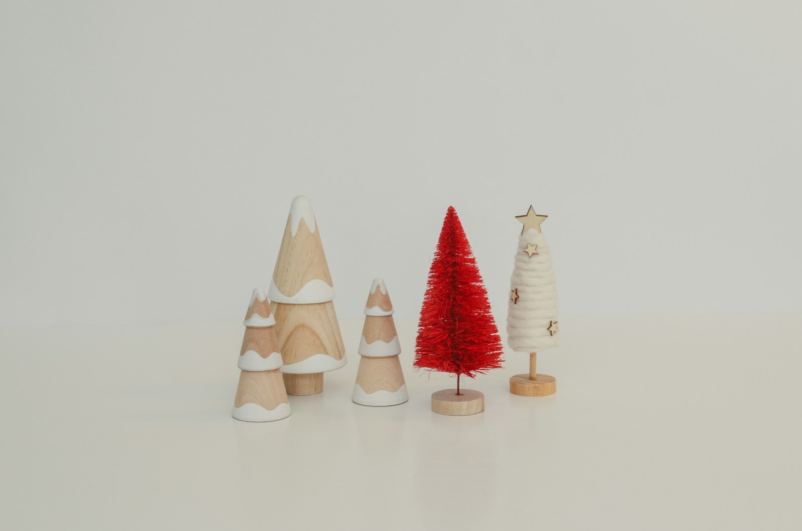 Small turned wooden trees in white and red standing in a row