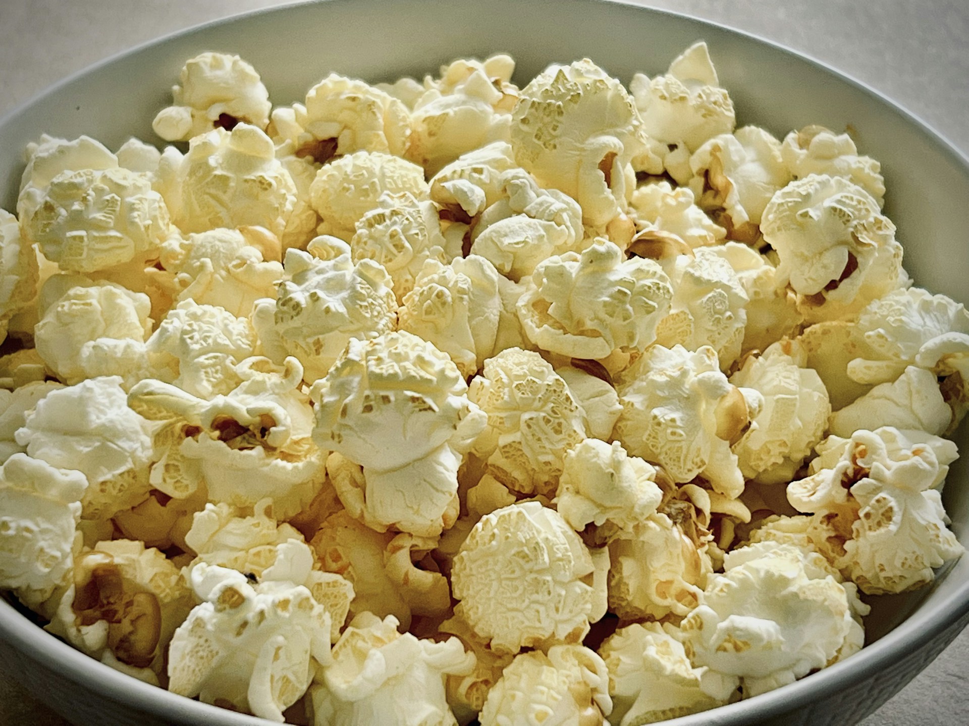 A white bowl filled with fresh fluffy popcorn