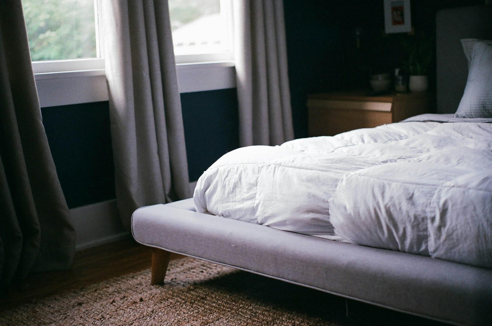 Bed making tricks for a fluffy white duvet piled on a bed by a window