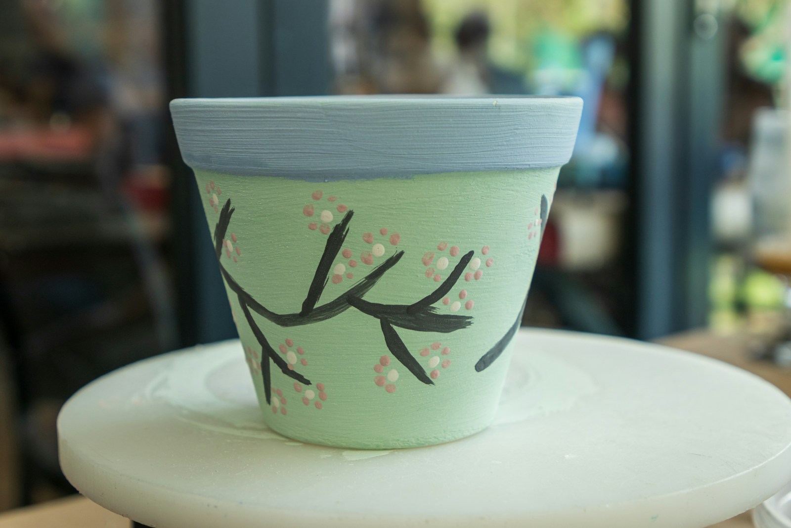Mint green pot painted with a cherry blossom branch