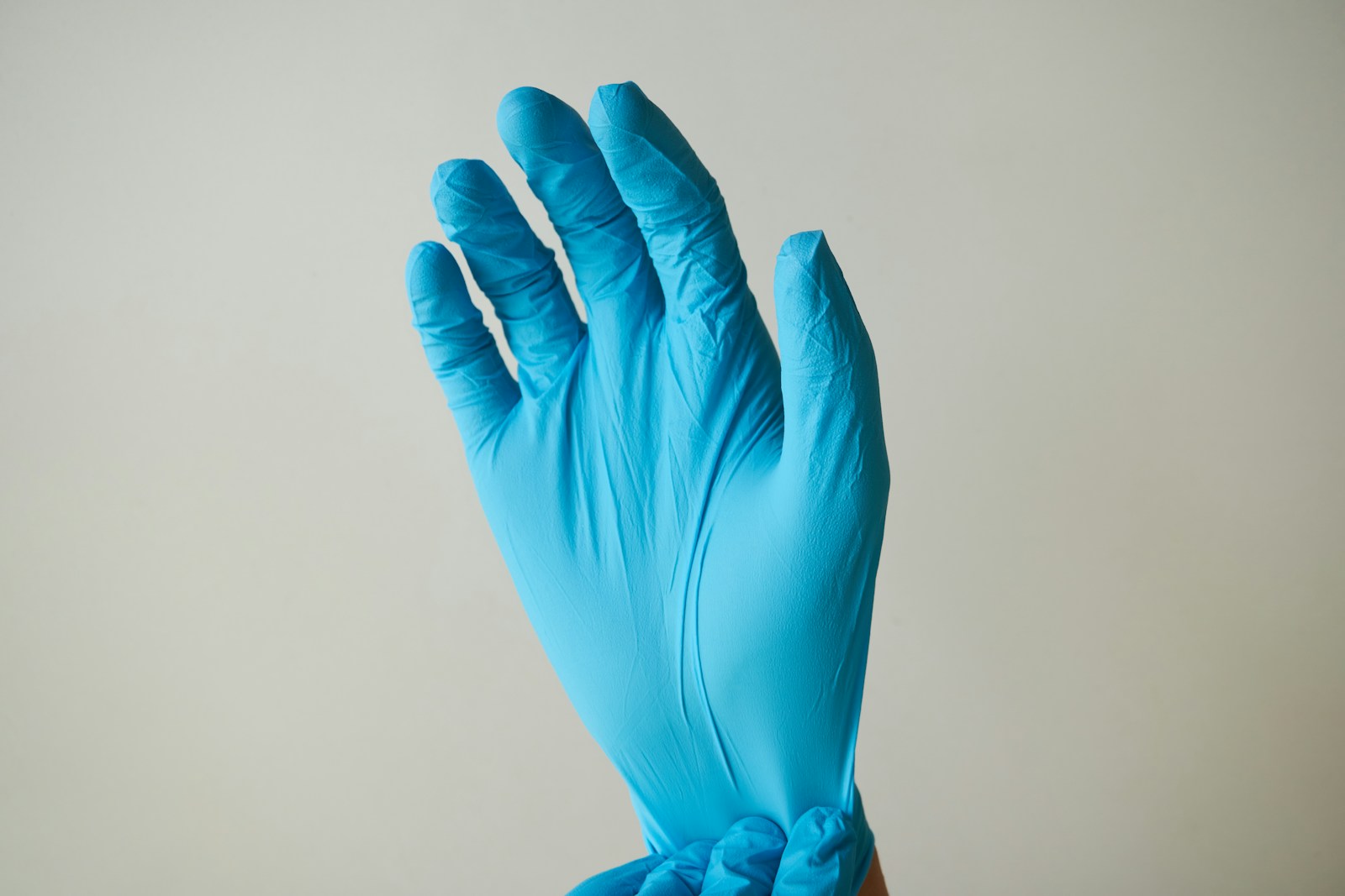 Hand wearing a blue nitrile glove for safe resin work