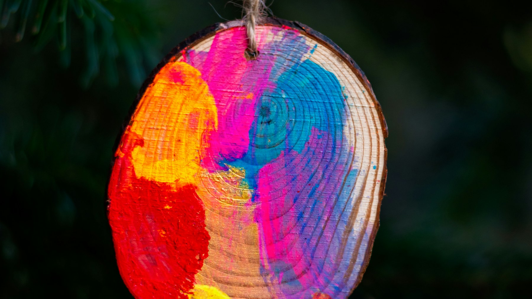 Hand painted wood slice ornament hanging on a Christmas tree