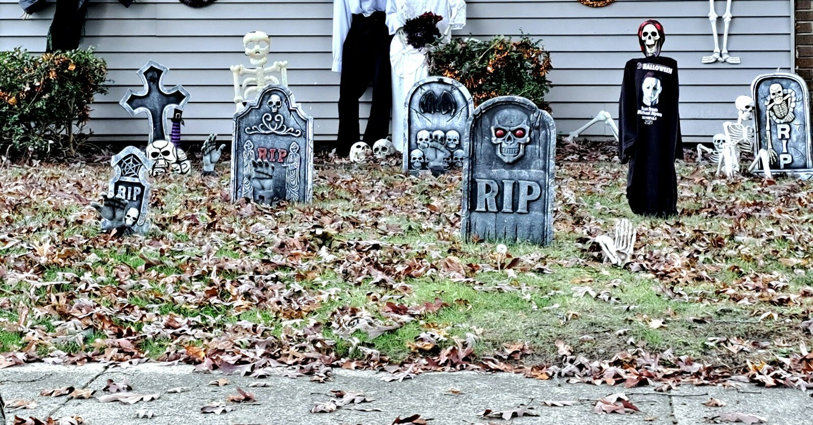 Front yard Halloween display with homemade tombstones on the lawn