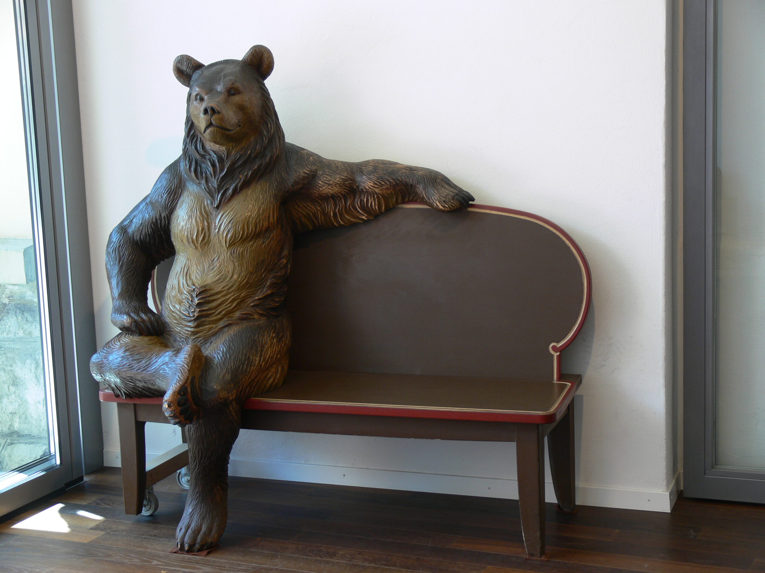 Giant bear chainsaw carving style bear sitting on a bench in Brienz