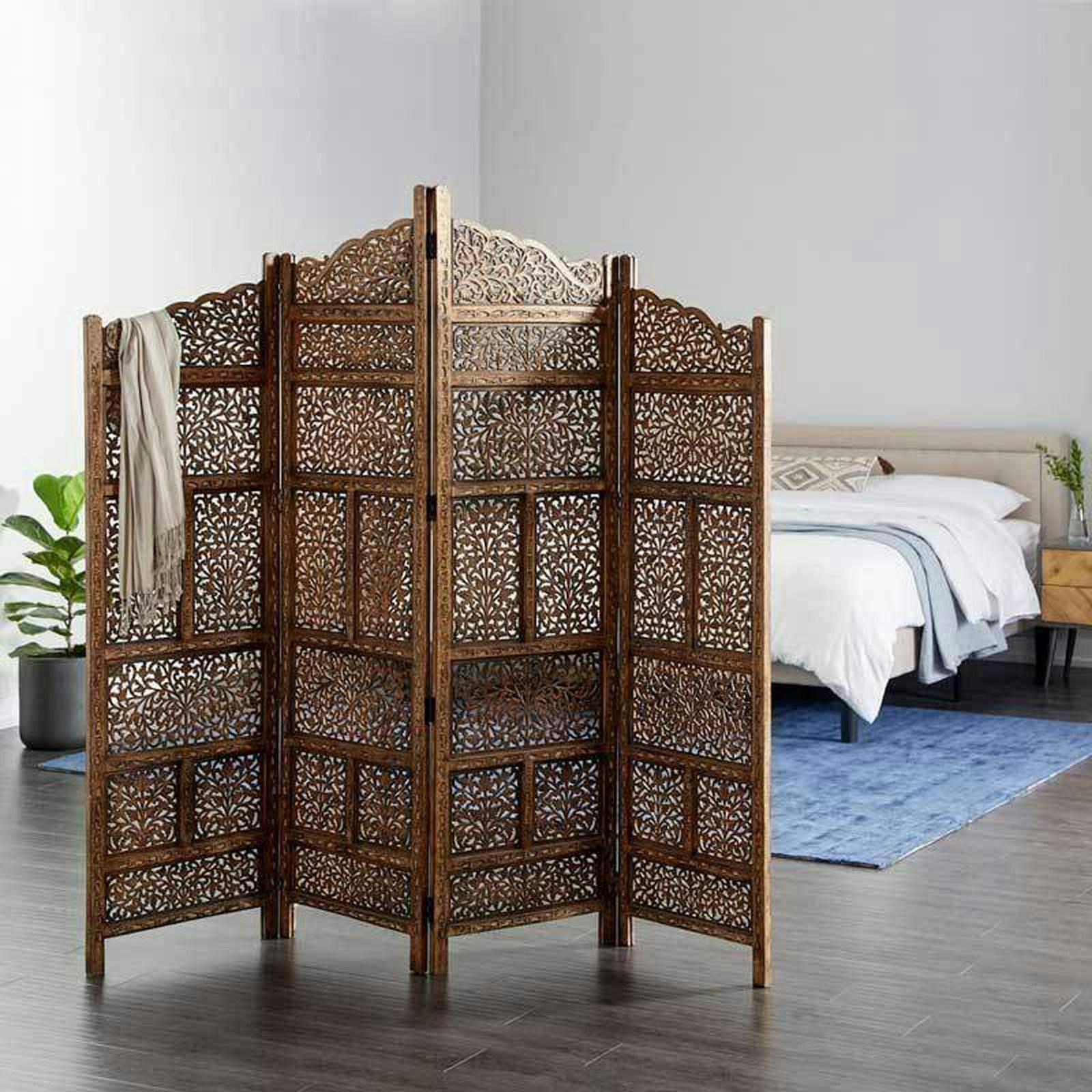 Carved wooden folding screen standing in a room corner