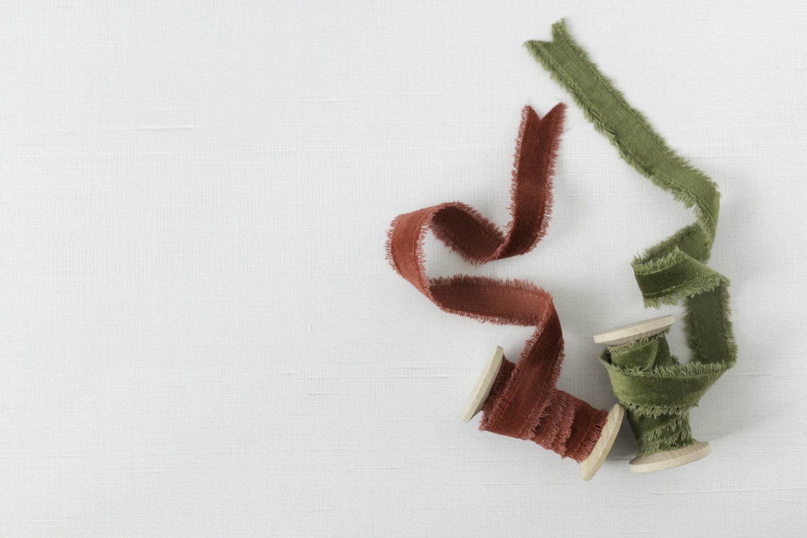 Two spools of red and green velvet ribbon for a ribbon loop wreath