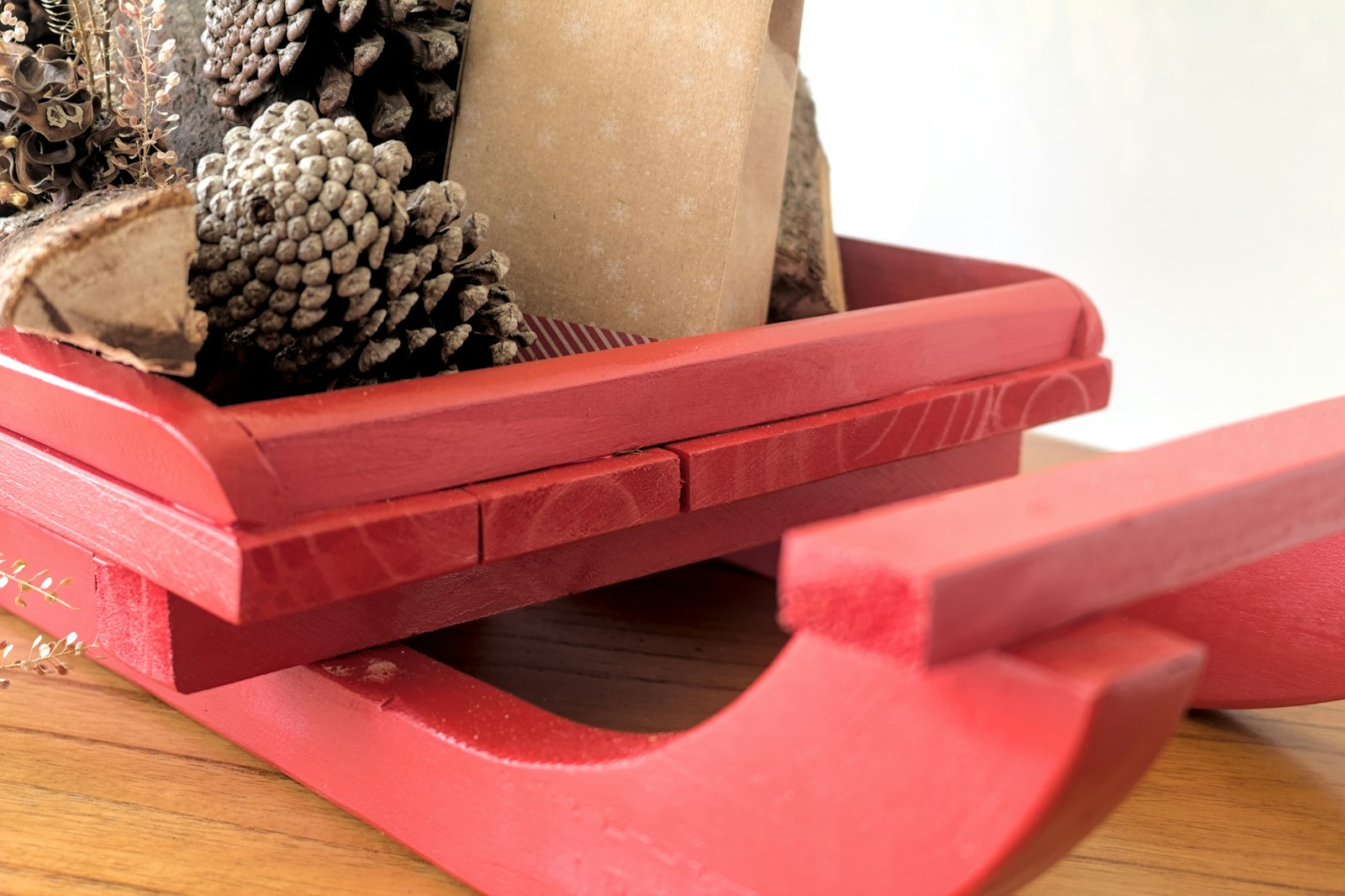 Little red wooden sled filled with pinecones, a simple vintage winter display