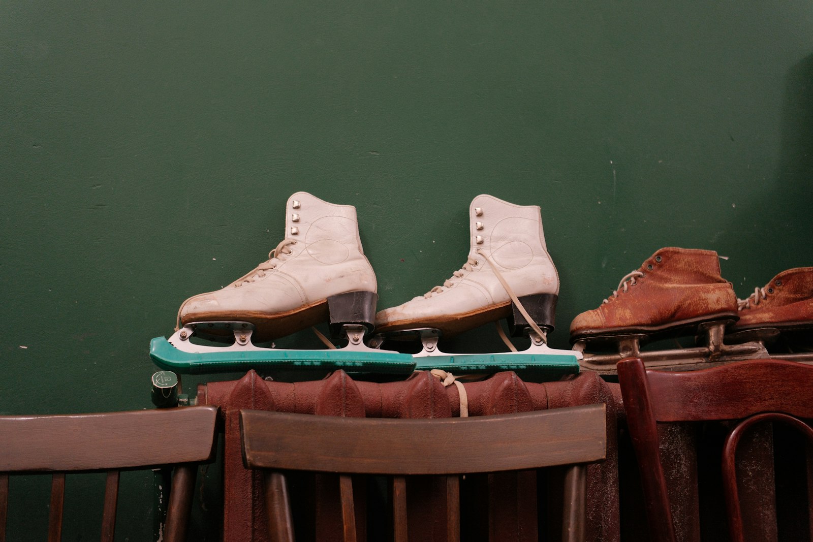 Pairs of vintage leather ice skates lined up on display
