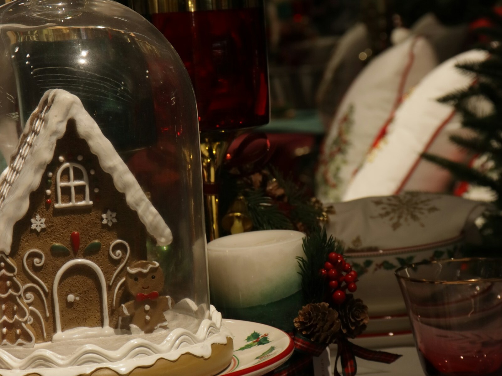 Gingerbread house under a dome with holiday dishes