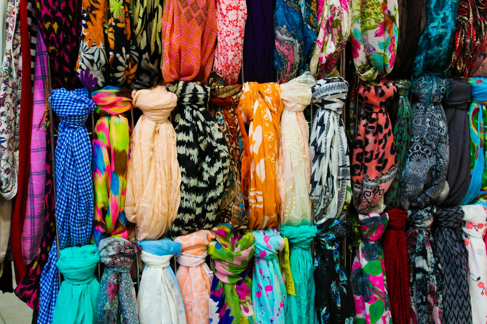 Colorful printed scarves hanging in neat rows