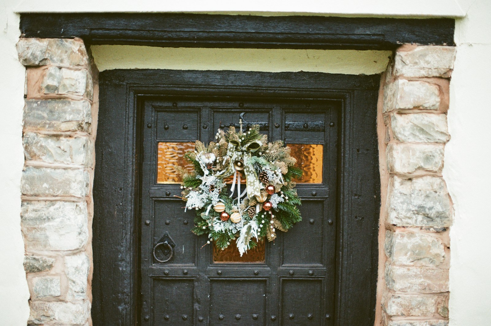 Dark wooden front door with a festive wreath