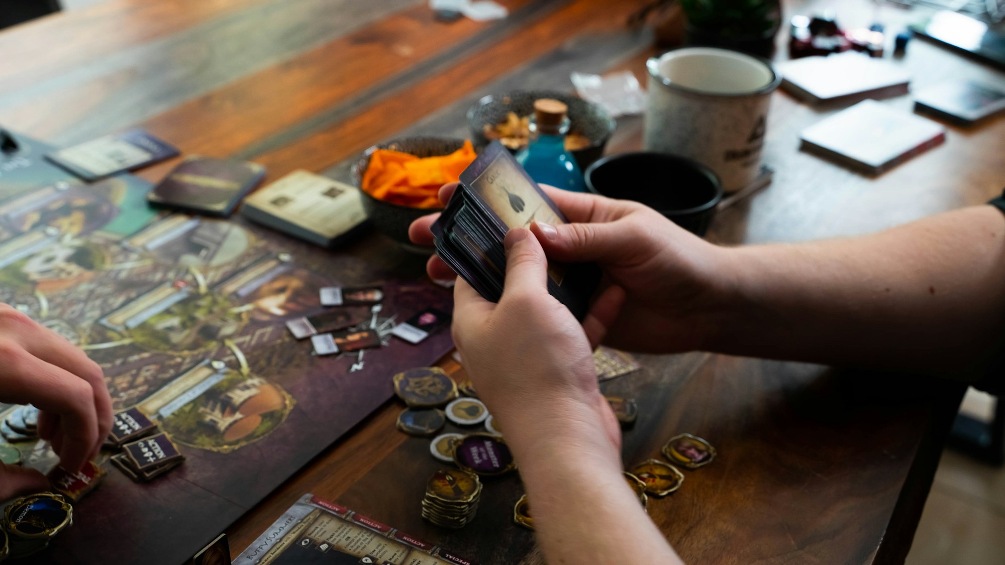 Hands playing a board game on a wooden table
