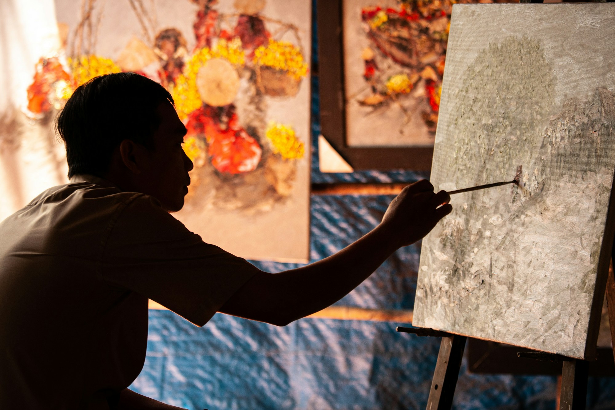 Silhouette of a person painting colorful art at home