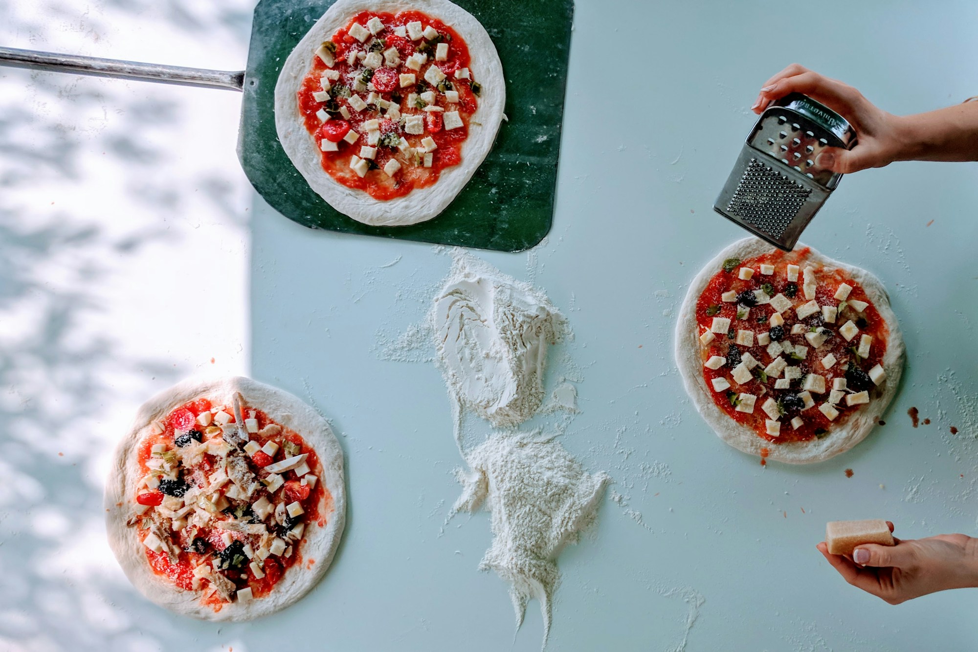 Homemade pizzas being topped for a date night at home