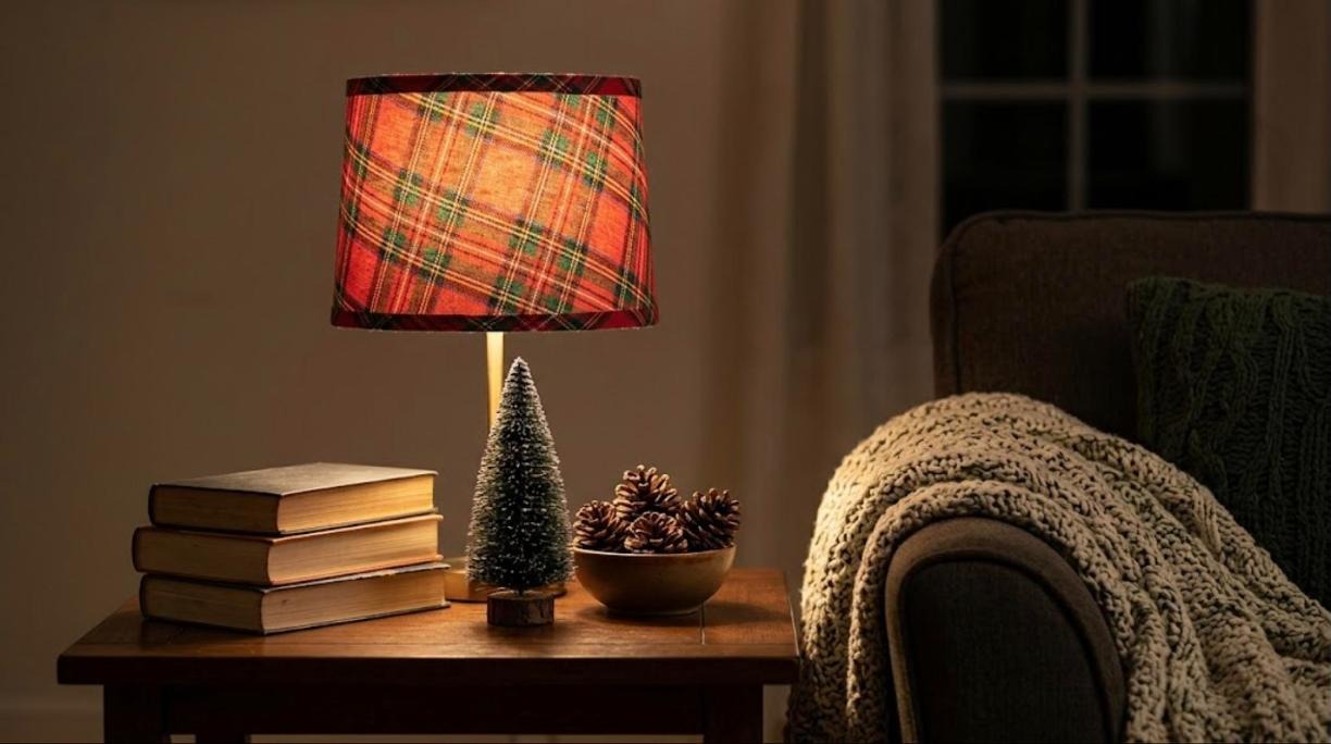 Christmas decorating hacks for lamps, a drum shade wrapped in red and green tartan fabric beside books