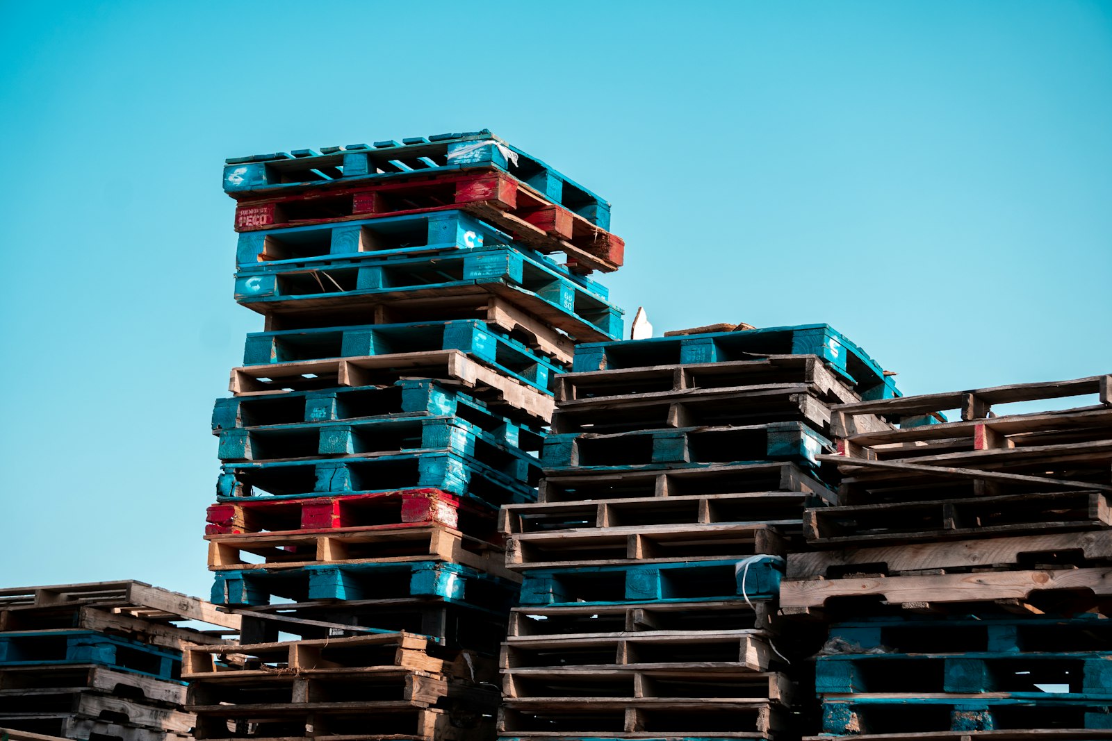 Stack of wooden pallets used to raise DIY cat shelters off cold ground