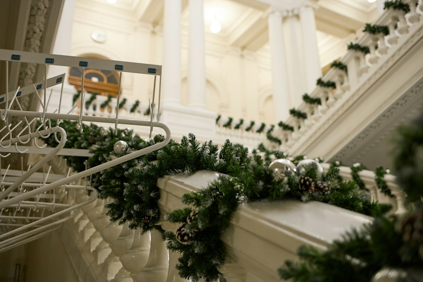 DIY Christmas garland wrapped along a white staircase banister
