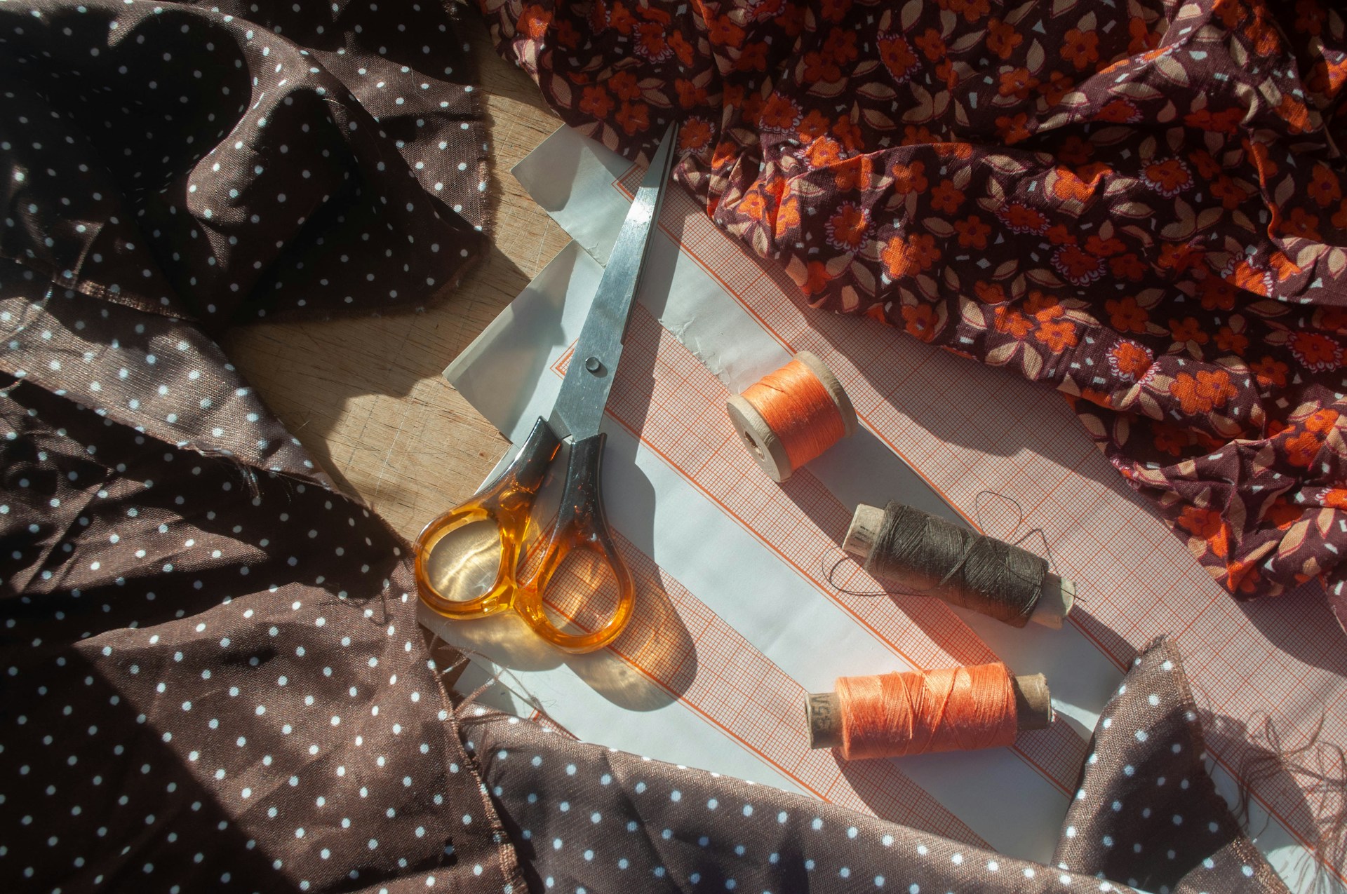Scissors and spools of thread on fabric ready for making DIY Christmas gift tags