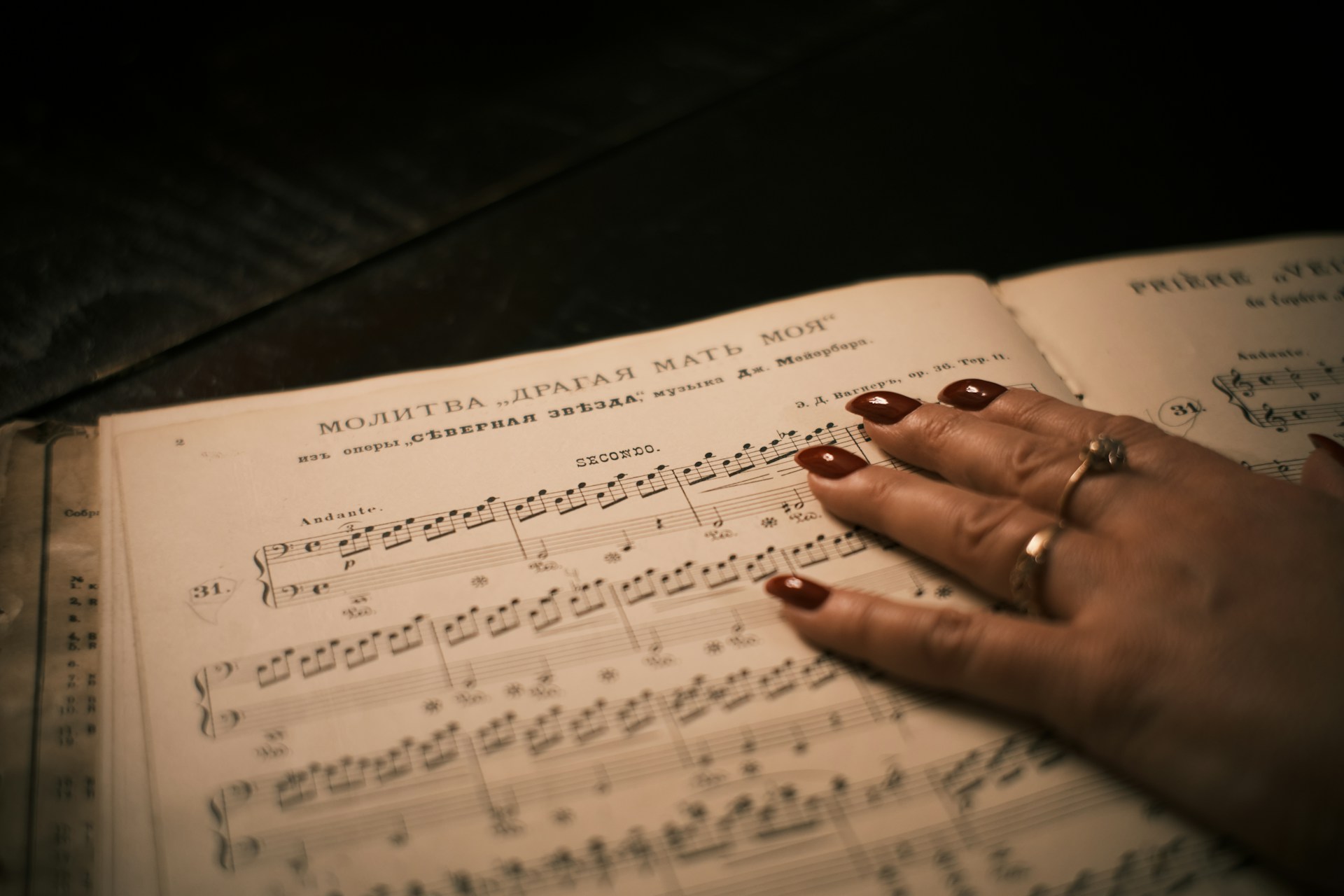 Hand resting on old sheet music