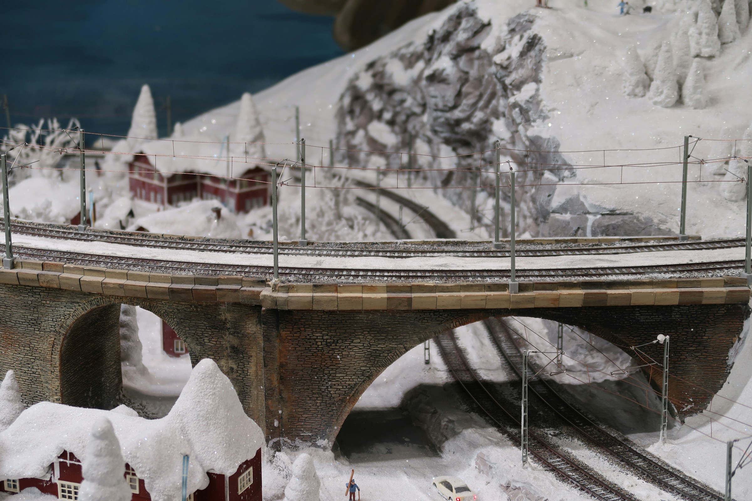 Snowy miniature landscape with hills, a stone bridge and tiny red houses