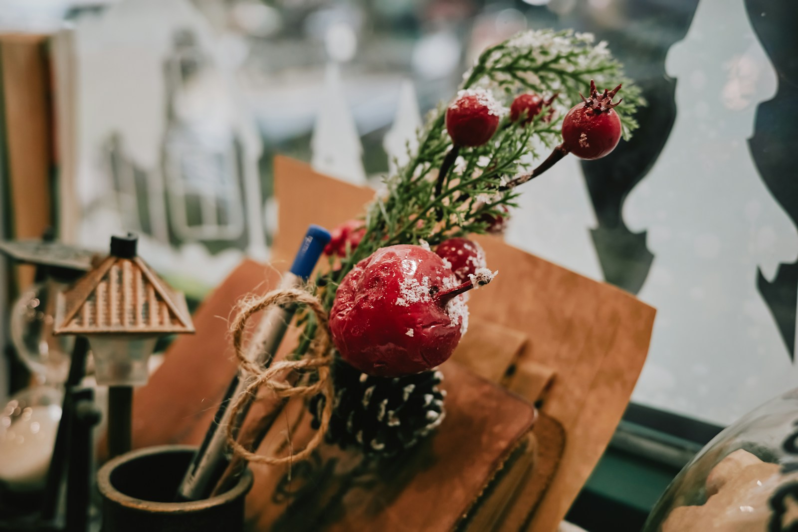Wrapped gift topped with evergreen, pine cones and berries