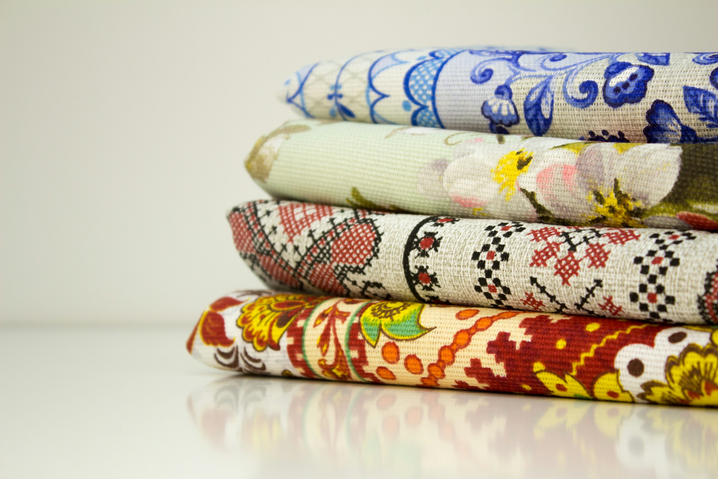Stack of folded printed cotton fabrics in red and blue patterns
