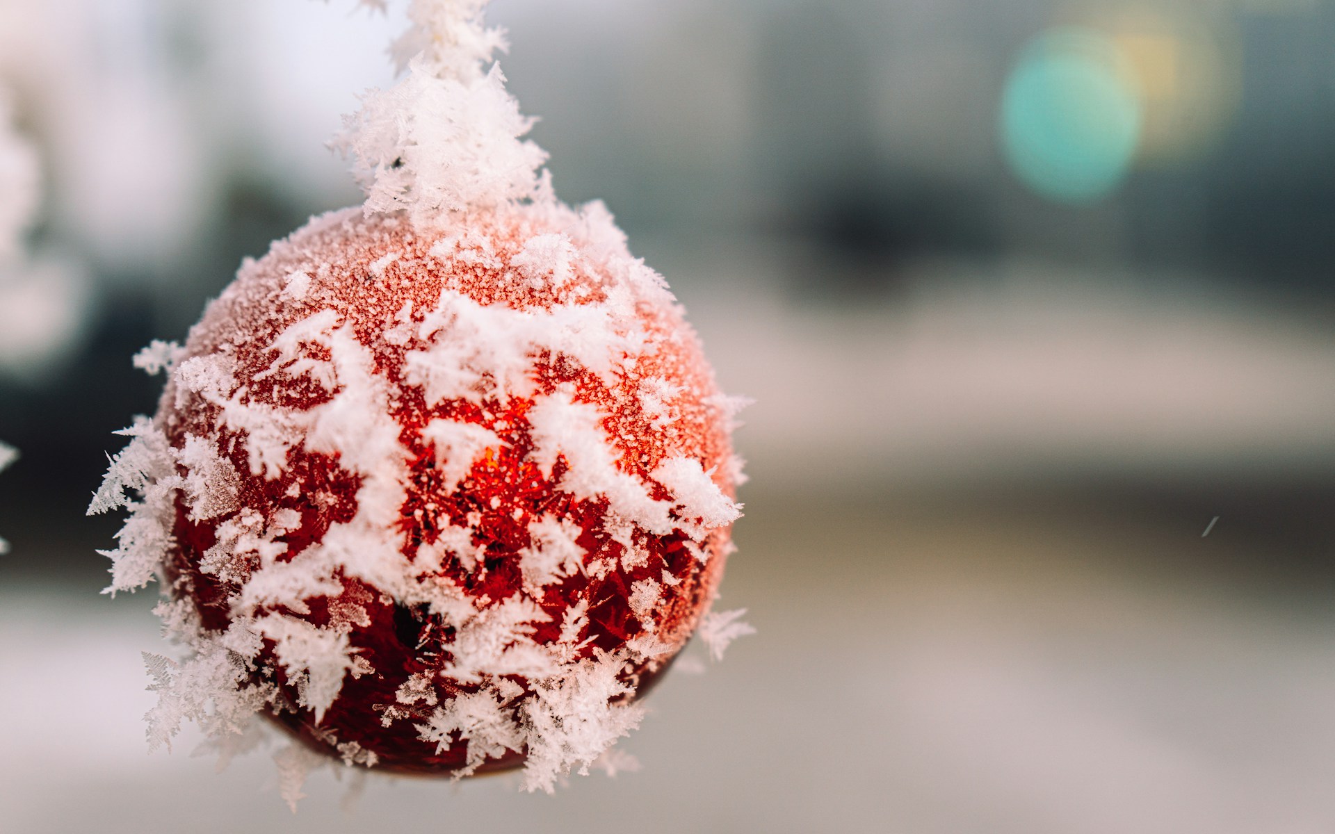Red Christmas ornament coated in white faux snow crystals